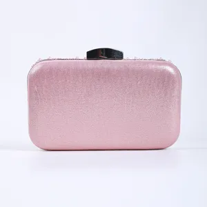 Close-up detail of a pink evening clutch bag with delicate pearl beaded trim and metal clasp.