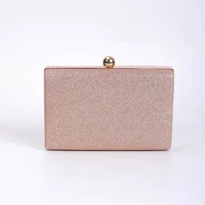 Pink glitter evening clutch bag with gold metal frame and spherical clasp, detailed view.