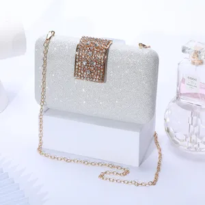 Silver glitter evening clutch bag with rhinestone clasp and gold chain strap for parties.