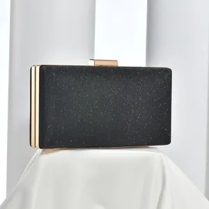Black glitter evening clutch detail, featuring elegant gold metal frame and secure clasp.