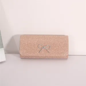 Elegant pink glitter evening clutch bag with sparkling rhinestone bow for women parties.