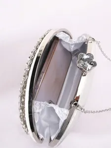 Gros plan détaillé de l'intérieur de la pochette de soirée et du fermoir en cristal scintillant.