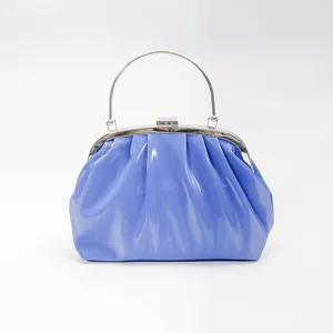Detail view of the blue pleated cloud handbag with metal handle and kiss-lock clasp design.