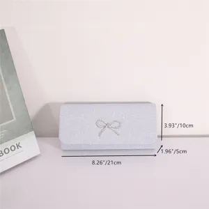 Silver glitter evening clutch bag with elegant rhinestone bow for wedding party prom use.