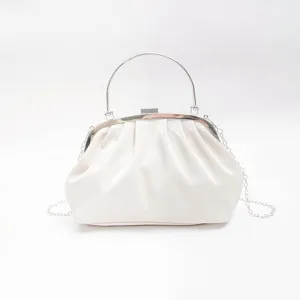 White glossy pleated clutch bag detail, elegant evening handbag with metal handle and chain.