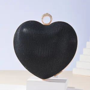 Black heart-shaped rhinestone clutch bag with gold metal frame and ring clasp for evening party.