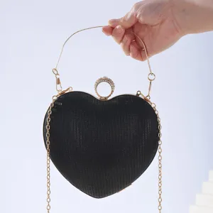 Detail view of the black heart-shaped evening bag featuring rhinestone embellishment and chain.