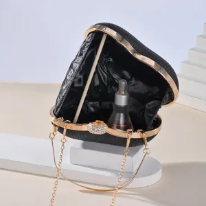 Detailed view of the sparkling heart evening clutch with rhinestone clasp and gold chain strap.