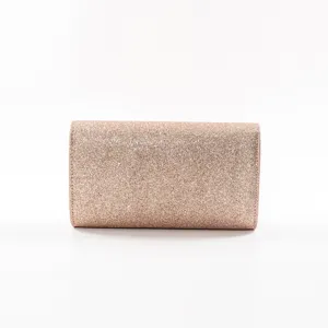Close-up view of the glittering rose gold evening clutch bag showing its fine texture.