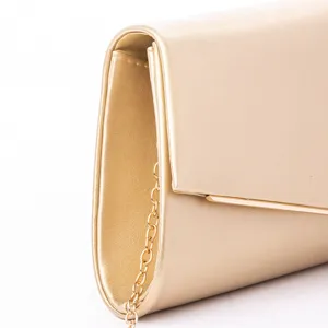 Primo piano dettagliato di una lussuosa pochette da sera dorata con sottile catena.