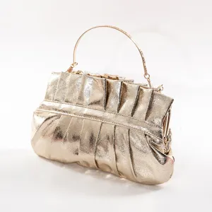 Gold metallic pleated evening clutch bag with metal handle, elegant vintage style detail.