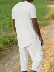 Detail shot of men's white waffle knit short sleeve top and cargo pants in outdoor scene.