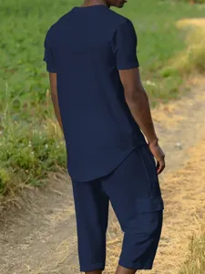 Detail shot of men's blue waffle knit casual top and cargo pants in an outdoor setting.