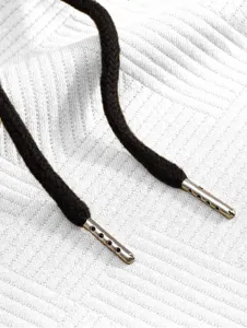 Vue détaillée du cordon sweat jacquard homme avec embout métallique et tissu blanc texturé.