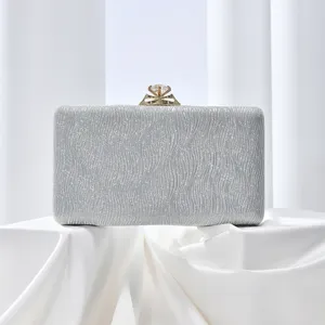 Silver sparkly evening clutch bag with diamond clasp detail, elegant design for parties.