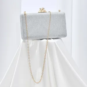 Silver sparkly evening clutch bag with chic chain strap and crystal clasp detail.