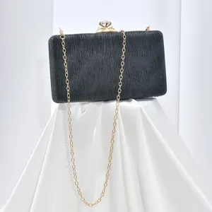 Elegant black evening clutch bag with sparkling diamond clasp and chic gold chain strap for party.