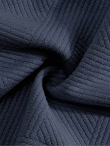 Gros plan d'un tissu côtelé en jacquard bleu foncé, montrant une texture claire et souple.