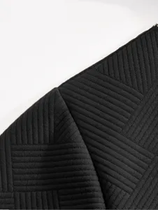 Gros plan detail du tissu texture jacquard noir pour homme montrant un motif elegant.
