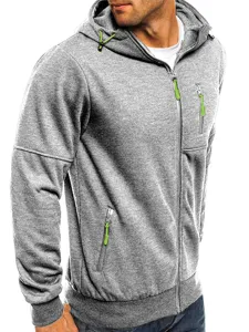 Close-up detail of grey hooded sweatshirt with vibrant green zippers and functional front pockets.