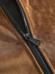 Nahaufnahme des Reißverschlusses einer braunen Herren Kunstwildlederjacke mit weicher Textur.