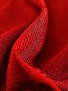 Nahaufnahme von hochwertigem rotem Strickstoff mit klarer Textur und weichen Falten.