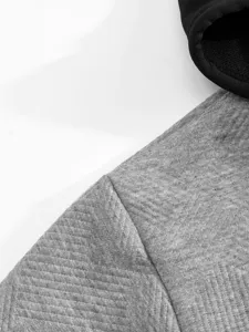 Gros plan sur le tissu gris texturé en jacquard et le design de capuche noire.