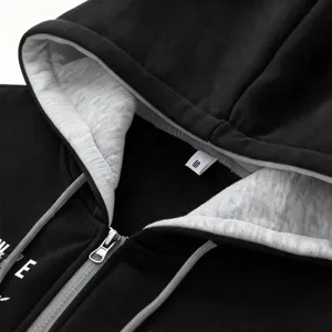 Close-up detail of black zip-up hoodie featuring cozy grey fleece lining and metal zipper.