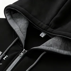 Men's autumn winter black zip-up hoodie detail view with contrast grey hood lining and zipper.