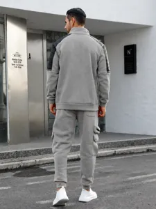 Detail view of men's grey fleece tracksuit featuring black shoulder panels and cargo pants.