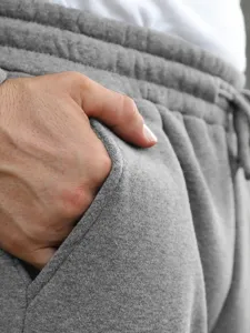 Close-up detail of men casual gray sweatpants pocket and cotton fabric texture display.