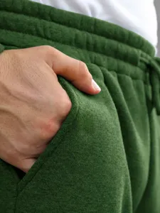 Green sweatpants pocket detail view, casual sportswear pants close-up display