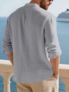 Detail shot of men's casual linen long sleeve shirt in light grey, lifestyle coastal view.