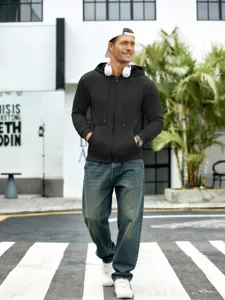 Vue détaillée en gros plan du sweat-shirt noir à capuche zippé porté en extérieur sur rue.