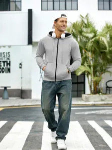 Scène extérieure montrant un sweat-shirt à capuche gris zippé et un jean pour homme.