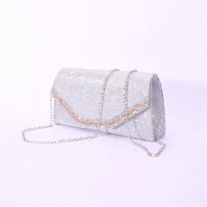 Silver glitter evening clutch bag close-up, sparkly rhinestone wedding party purse with chain.