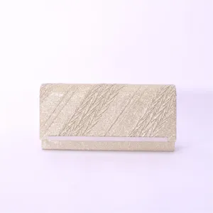 Detailed close-up of a sparkling gold glitter evening clutch bag with sleek metal accent trim.