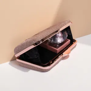 Detail view of a stunning rose gold glitter evening clutch bag with elegant metallic frame.