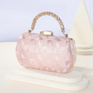 Detalle de bolso de noche de satén con asa de diamantes y textura rosa geométrica.