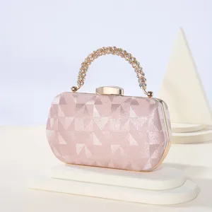 Bolso de noche rosa con asa de estrás detalle primer plano textura geométrica