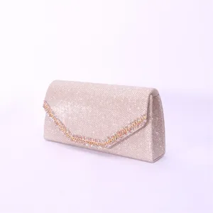 Glitter evening clutch bag detail showing sparkling sequin texture and rhinestone chain decoration.