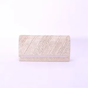 Detailed view of the elegant gold glitter evening clutch bag featuring a sleek metal accent strip.