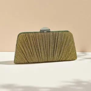 Close-up of the elegant gold pleated evening clutch featuring a shiny metallic clasp hardware.