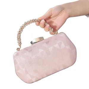 Vista detallada del bolso de noche de saten rosa con brillante asa de estras para mujeres.