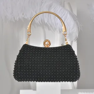 Elegant black pearl evening bag with gold metal handle and luxury clutch design for party.