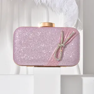 Pink glitter evening clutch bag detail, elegant rhinestone bow, luxury party handbag for women.