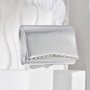 Detailed close-up of the stylish silver evening clutch bag with elegant metallic wave trim.
