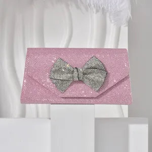 Rhinestone bow rhinestone detail on pink glitter evening clutch bag close-up view