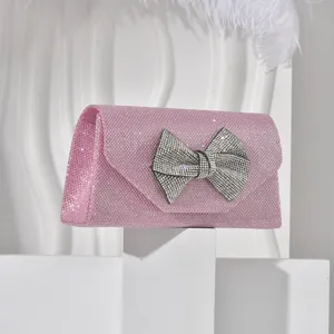 Pink glitter evening clutch bag with rhinestone bow detail, elegant crossbody bag for women.