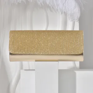 Golden fine glitter clutch handbag detail, elegant evening party bag structure and sparkly fabric texture.